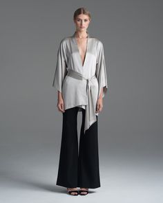 VOZ's luxurious Silk Kimono is made of two layers of pure charmeuse and comes with matching belt featuring tapered edges. This modern version of a timeless style offers perfect versatility, to be paired with jeans and heels or worn to a gala. Available in Black and Silver, the kimono is One Size Fits All, and handmade in New York. 100% silk body with 100% silk lining, Made in New York Model is 5'10", product is One Size Product Care: Dry Clean Only Ethical Clothing, Silk Kimono, Black And Silver, Ethical Fashion, Kimonos, Beautiful Fashion, Fashion Company, One Size Fits All, Duster Coat