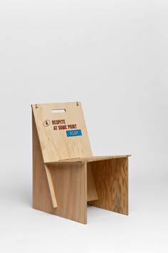 a chair made out of plywood with the seat folded back to reveal an empty box