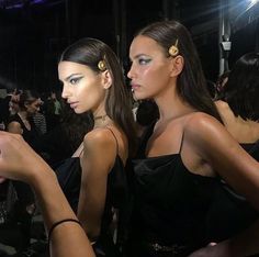 two models are looking at their cell phones