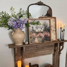 a vase filled with flowers sitting on top of a mantle