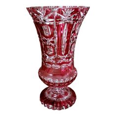 a red glass vase sitting on top of a table