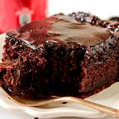 a piece of chocolate cake sitting on top of a white plate next to a fork