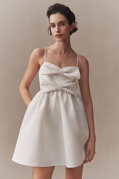 The Sachin & Babi Sloane Mini Dress features two layers of dimensional, feminine bows, pearl embellishments, and a charmingly voluminous skirt. The flirty, mini silhouette is finished with delicate spaghetti straps and pleated details - fit for a storybook romance. | Sloane Taffeta Pearl Double-Bow Pleated Mini Dress by Sachin & Babi in White, Women's, Size: Medium, Polyester at Anthropologie Evening Organza Dress With Bow, Formal Organza Dress With Bow, Chic Wedding Dress With Bow Tie Back, Elegant Organza Dresses With Bow Detail, Elegant Organza Dresses With Bow, Spring Wedding Mini Dress With Bow Tie Back, Embellished Satin Mini Dress For Wedding, Feminine Mini Dress With Bow Tie Back For Wedding, Feminine Bow Tie Back Mini Dress For Wedding