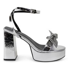 Step into the spotlight with Isabella, the silver platform sandal that will elevate any outfit! Featuring a removable crystal bow, you can play up the glamour or keep it simple. Heel Height 5" Platform height 1.5" Material Vegan Leather Silver Platforms, Gorgeous Shoes, Keep It Simple, Platform Sandals, Vegan Leather, Heel Height, Sandals, Canning, Heels