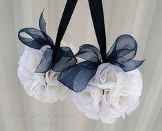 a white flower bouquet hanging from a black ribbon