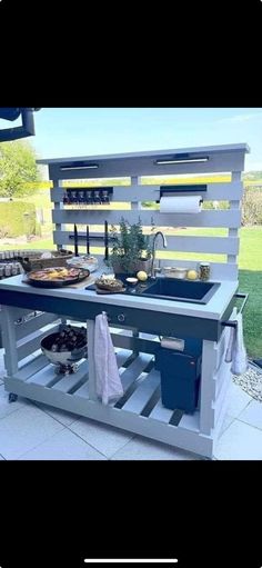 an outdoor kitchen made out of pallets and wooden planks with food on it