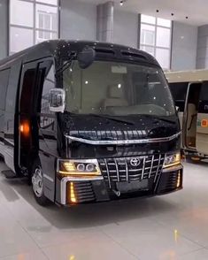 a black bus is parked in an empty building