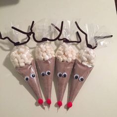 three cones filled with marshmallows and googly eyes