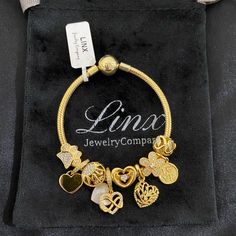 Linx Snake Chain Style Charm Bracelet With A Ball Clasp, Featuring Linx Logo. The Bracelet Comes With 9 Linx Charms As Shown. *All Items Are 14k Yellow Gold Over 925 Sterling Silver. *Linx Bracelets And Charms Are Very Well Made And Of Superior Quality, Designed To Last. These Pieces Come With A 100% Satisfaction Guarantee Or Your Money Back. *The Bracelet Is Available In Multiple Sizes *Additional Charms Can Also Be Added To The Bracelet And The Ones Included Are Removable As Well. *Linx Bracel Elegant Metal Charm Bracelet With Removable Charms, Elegant Crystal Charm Bracelet As A Gift, Elegant Crystal Charm Bracelet Gift, Elegant Crystal Bracelet With Charms For Gift, Elegant Gold Jewelry With Removable Charms, Elegant Gold Plated Charms, Gold Charm Bracelet With Cubic Zirconia, Elegant Gold-plated Jewelry With Removable Charms, Gold Cubic Zirconia Bracelet With Charms