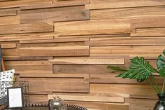 a wooden wall behind a coffee table with two vases on it and a plant