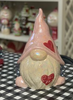 a glass gnome figurine sitting on top of a checkered tablecloth covered table