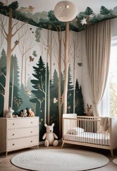 a baby's room with a forest mural on the wall and a crib