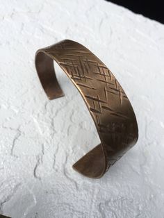 "This cuff bracelet is hand forged from solid bronze and has been textured with an organic cross hatched pattern. Bronze is a lovely metal and compliments any skin tone with its warm, rich hue. Bronze is the traditional gift for the 8th Anniversary. MEASUREMENTS & SPECIFICS: SIZE: ID is 2.5\" - cuffs are adjustable (one size fits most) Request a custom order for smaller or larger wrists WIDTH: tapers from approximately 1\" to .5\" METAL: Solid bronze 88/12 copper and tin FINISH: Choose from Adjustable Hand Forged Bronze Bracelets, Adjustable Etched Bronze Bracelets, Adjustable Hand Forged Bronze Cuff Bracelet, Adjustable Hammered Bronze Cuff Bracelet, Adjustable Hand Cast Bronze Bracelets, Rustic Adjustable Etched Jewelry, Adjustable Etched Bronze Cuff Bracelet, Adjustable Etched Metal Cuff Bracelet, Adjustable Etched Brass Cuff Bracelet