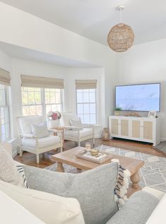 a living room filled with furniture and a flat screen tv on top of a wooden table