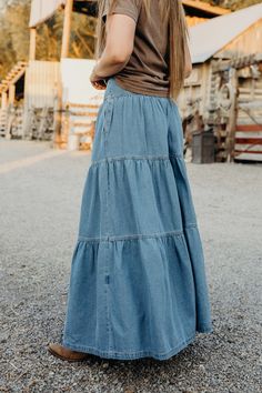 Get ready to twirl in style with The Lodonna Skirt. This light wash, tiered maxi skirt is made from soft denim and features side pockets for convenience. The elastic waistband provides a comfortable fit, while the western style adds a touch of flair. Haylee is wearing size small paired with the Horsin Around Tee and Parker Cardigan Spring Bohemian Wide Leg Denim Skirt, Spring Bohemian Wide-leg Denim Skirt, Bohemian Wide Leg Denim Skirt For Spring, Bohemian Dark Wash Bottoms For Spring, Relaxed Fit Tiered Skirt With Elastic Waistband, Relaxed Tiered Skirt For Spring, Summer Flowy Denim Maxi Skirt, Summer Denim Flowy Maxi Skirt, Bohemian Denim Maxi Skirt For Spring