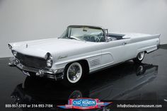 an old white car is on display in a museum