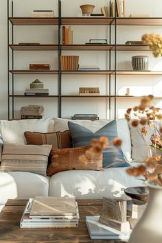 Cozy farmhouse living room with a soft beige sofa, decorative pillows, and a stylish open shelving unit filled with books and decor.