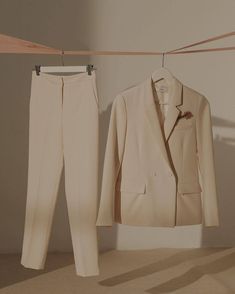 a white suit and pants hanging on a clothes line next to a shirt hanger