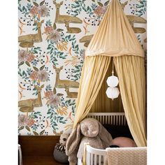 a baby's room with floral wallpaper and a canopy over the crib