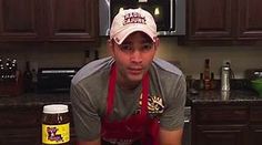 a man wearing an apron and hat with a jar of peanut butter in front of him