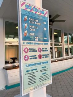 a sign is in front of a building with an ice cream shop on the corner