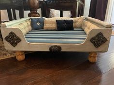 a dog bed made out of an old couch with pillows on the bottom and sides