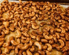 a pizza covered in cashews sitting on top of a pan