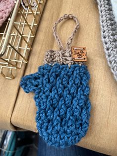 a blue crocheted purse sitting on top of a table