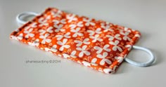 an orange and white flowered fabric pouch