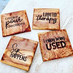 four wooden coasters with sayings on them