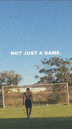 a man standing on top of a lush green field next to a soccer ball under a blue sky