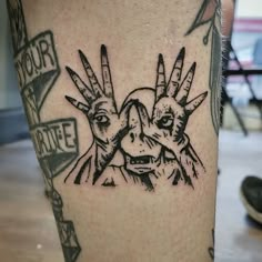 a close up of a person's leg with tattoos on it and two hands