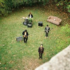 an overhead view of people playing music in the grass with couches and guitar equipment