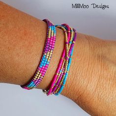 a woman's arm with three different colored bracelets on top of each other