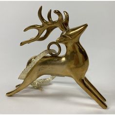 a golden metal deer statue sitting on top of a white table