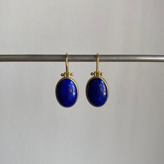 Striking blue Afghanistan lapis lazuli cabochons rest serenely within pristine gold bezels to make an effortlessly regal pairing. 18k yellow gold Lapis lazuli, 9.4ctw, 9mm x 13mm (3/8" x 1/2") Earrings hang 15/16" from the ear Each earring weighs 2.4g Classic Lapis Lazuli Yellow Gold Jewelry, Classic Yellow Gold Lapis Lazuli Jewelry, Classic Yellow Gold Jewelry With Lapis Lazuli, Luxury Lapis Lazuli Cabochon Jewelry, Yellow Gold Lapis Lazuli Cabochon Jewelry, Polished Yellow Gold Lapis Lazuli Jewelry, Yellow Gold Lapis Lazuli Jewelry With Polished Finish, Blue Bezel Set Earrings For Formal Occasions, Elegant Blue Oval Cabochon Earrings