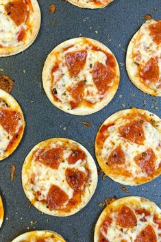 mini pizzas with cheese and pepperoni on a baking sheet