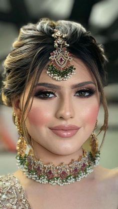 a woman in a bridal outfit with jewelry on her head