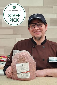 a man holding a bag of food in front of a sign that says staff pick