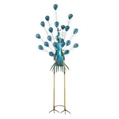 a metal peacock with blue feathers on it's head is standing in front of a white background