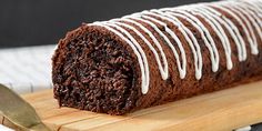 a loaf of chocolate cake sitting on top of a wooden cutting board