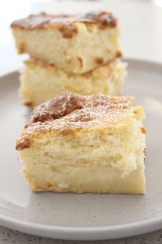 two pieces of cake sitting on top of a plate next to each other, with powdered sugar on top