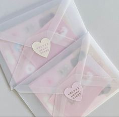 three envelopes with hearts on them and some stickers attached to the front one