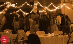 a group of people that are standing in front of a table with balloons on it