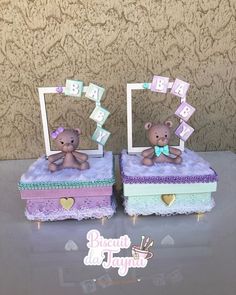 two small teddy bears sitting on top of purple and green boxes with letters that spell out baby