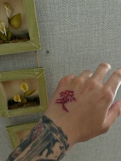 a person's hand with a small tattoo on the left wrist and right arm