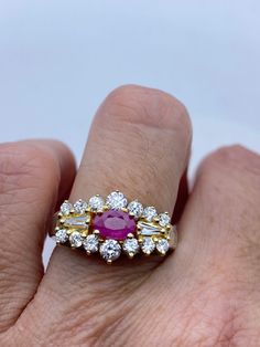 This is a vintage red ruby with tiny white sapphire ring set in gold 925 sterling silver set in a lovely pattern. Size 7 this can be sized to your specification, please message us to discuss sizing your ring or engraving options. Sizing costs $20, engraving $4 per letter.  All of our jewelry is hand polished and shipped to you in a stylish gift box.  We are happy to gift wrap for you.  It is important to us that each customer be thrilled with their purchase.  We are grateful for thousands of pos Red Ruby Ring With Diamond Accents, Dazzling Red Ruby Ring With Diamond Accents, Vintage White Ruby Ring For Anniversary, Red Diamond Ring With Accents, Dazzling Red Diamond Ring With Diamond Accents, Dazzling Red Diamond Ring With Accents, Dazzling Ruby Ring With Vvs Clarity, Classic Cubic Zirconia Ruby Ring, Exquisite Ruby Ring With Diamond Accents