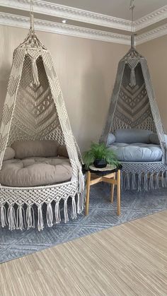 two hammocks with tassels hanging from the ceiling in a living room