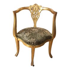 an ornately decorated chair with gold paint and fabric upholstered on the back