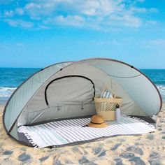 a tent on the beach with a picnic basket